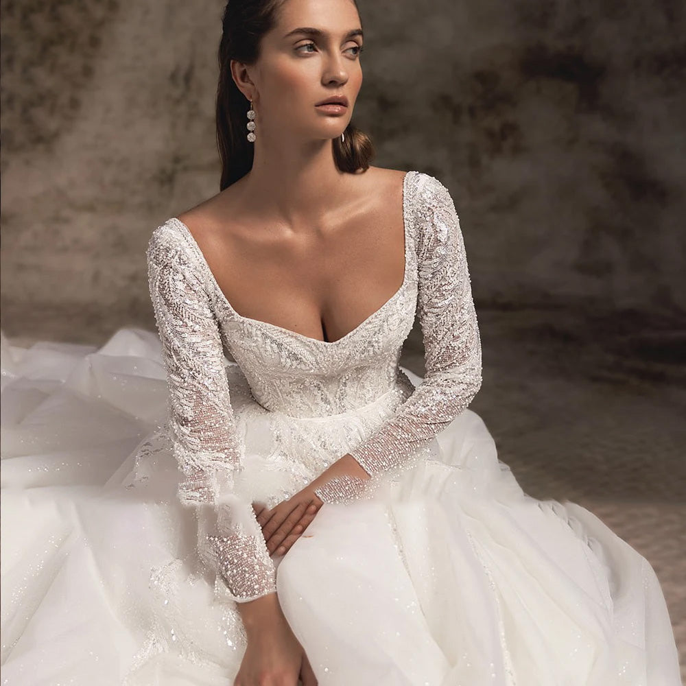 Close-up of the bridal gown’s bodice, emphasizing the V-neck, cap sleeves, and exquisite floral lace embroidery.