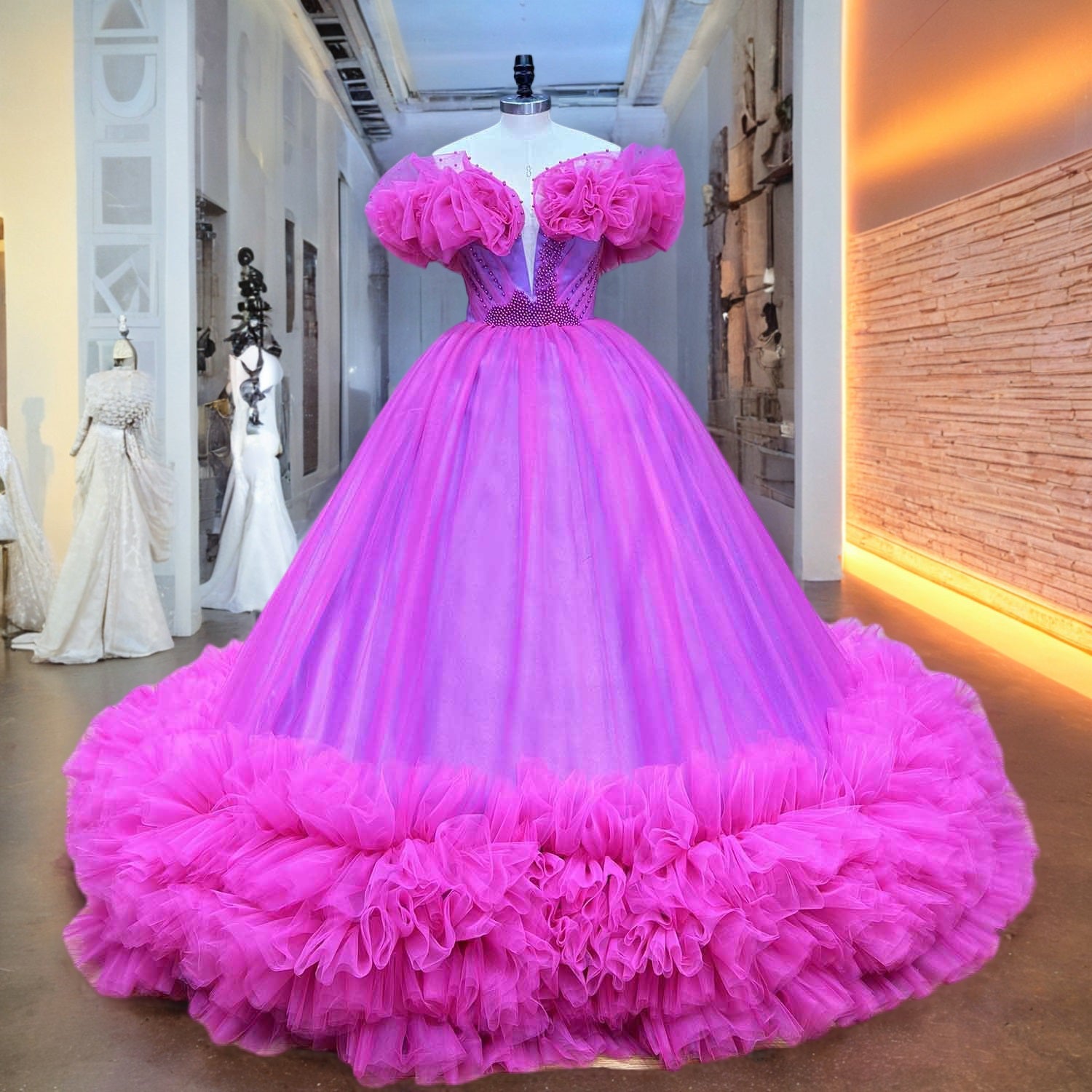 Fuchsia tulle ball gown wedding dress with a plunge neckline and matching pearl embellishments displayed on a mannequin in a bridal boutique corridor.