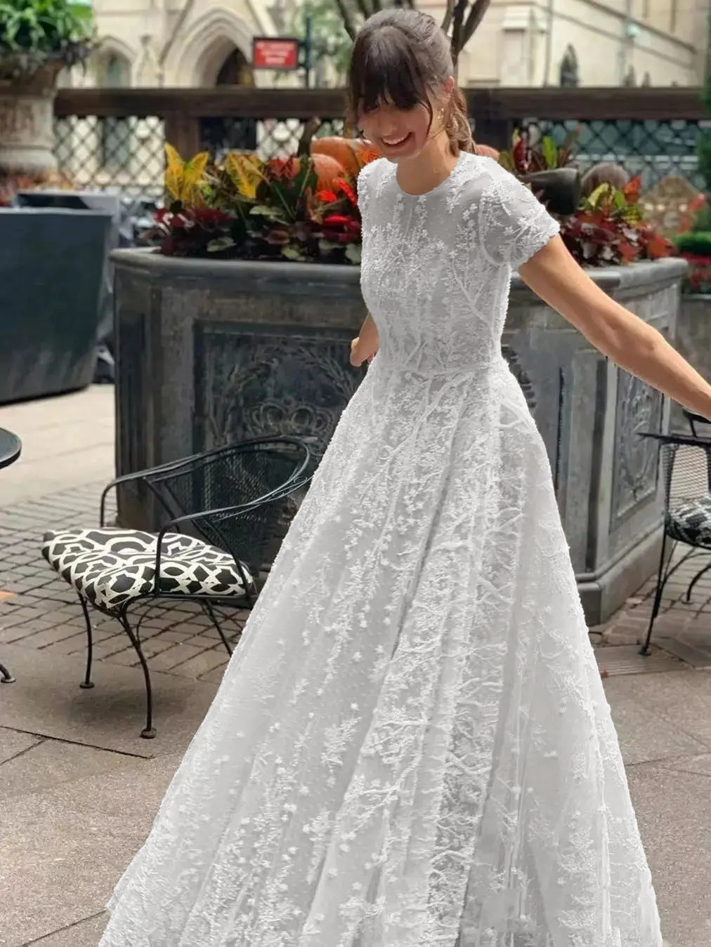 A candid shot of a bride in a vintage lace appliqué wedding dress, showcasing the intricate short-sleeve design.