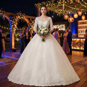 Bride wearing an elegant half-sleeve lace ball gown wedding dress at an evening reception ceremony.