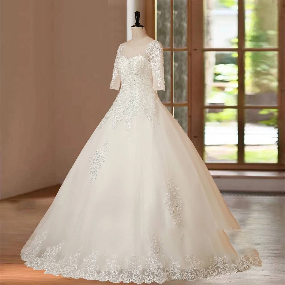 Full-length shot of a bridal ball gown with half sleeves and a floor-length skirt displayed on a mannequin in a boutique.