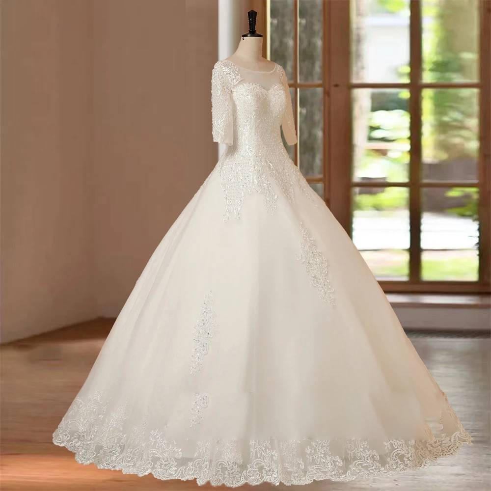Full-length shot of a bridal ball gown with half sleeves and a floor-length skirt displayed on a mannequin in a boutique.