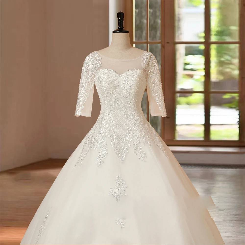 Close-up view of the bodice of a half-sleeve wedding dress, highlighting the intricate lace embroidery and sweetheart neckline.