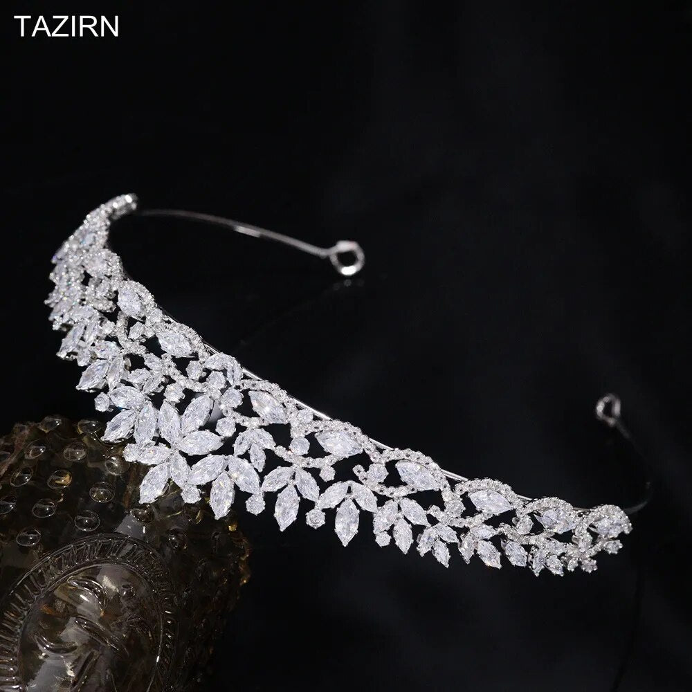 High-angle shot of a flexible silver-plated crystal bridal crown band showcasing the sweeping leaf vine setting against a dark black studio background.