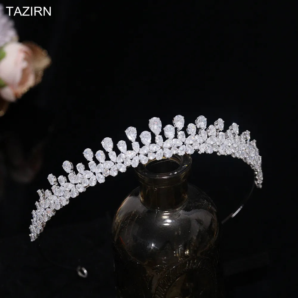 Angled close-up product photograph focusing on the crown tip settings and pear-shaped teardrop crystal clusters of a premium silver bridal tiara.