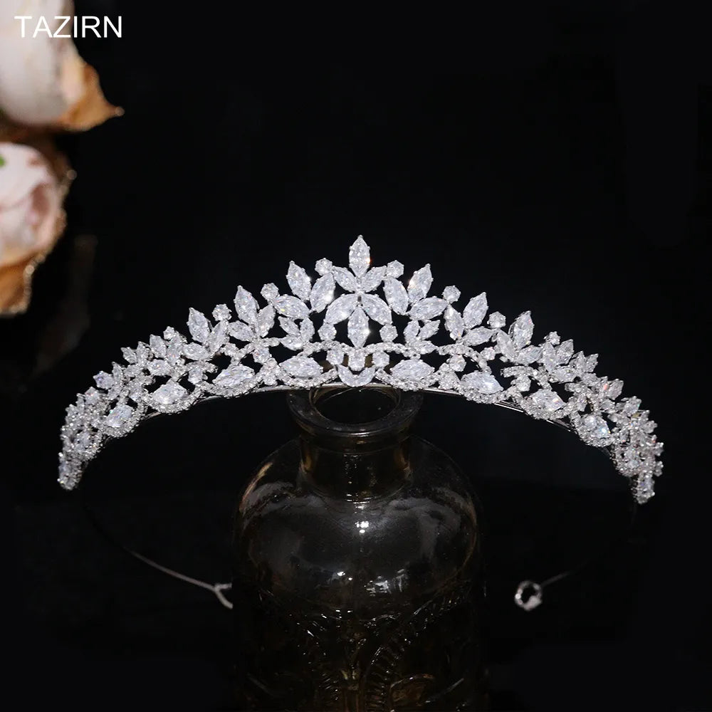 Straight-on product shot of a silver floral CZ wedding tiara with marquise micro-inlays, balanced upright over a dark decorative display bottle.