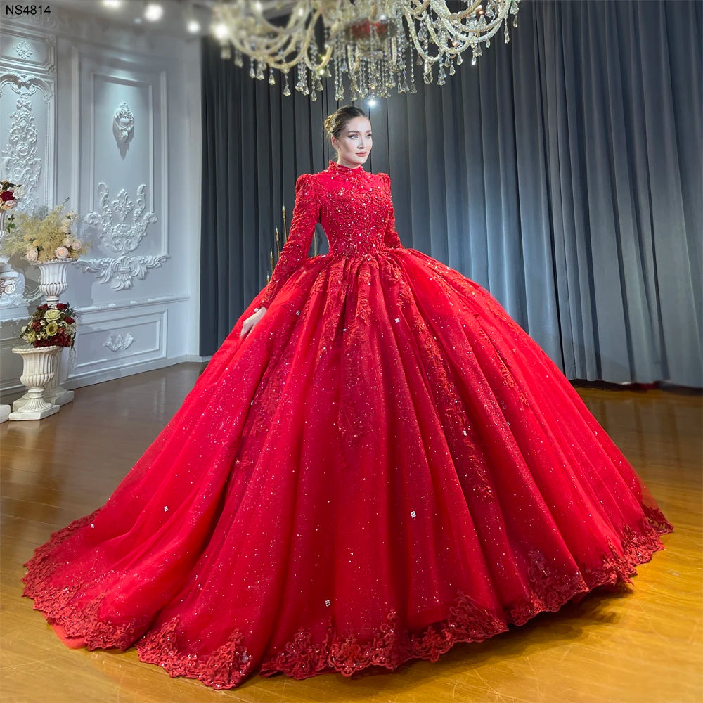 Full front view of a model showcasing a stunning full coverage wine red Muslim wedding dress featuring a high neckline, long sleeves, and a voluminous ball gown skirt with heavy hand beading.