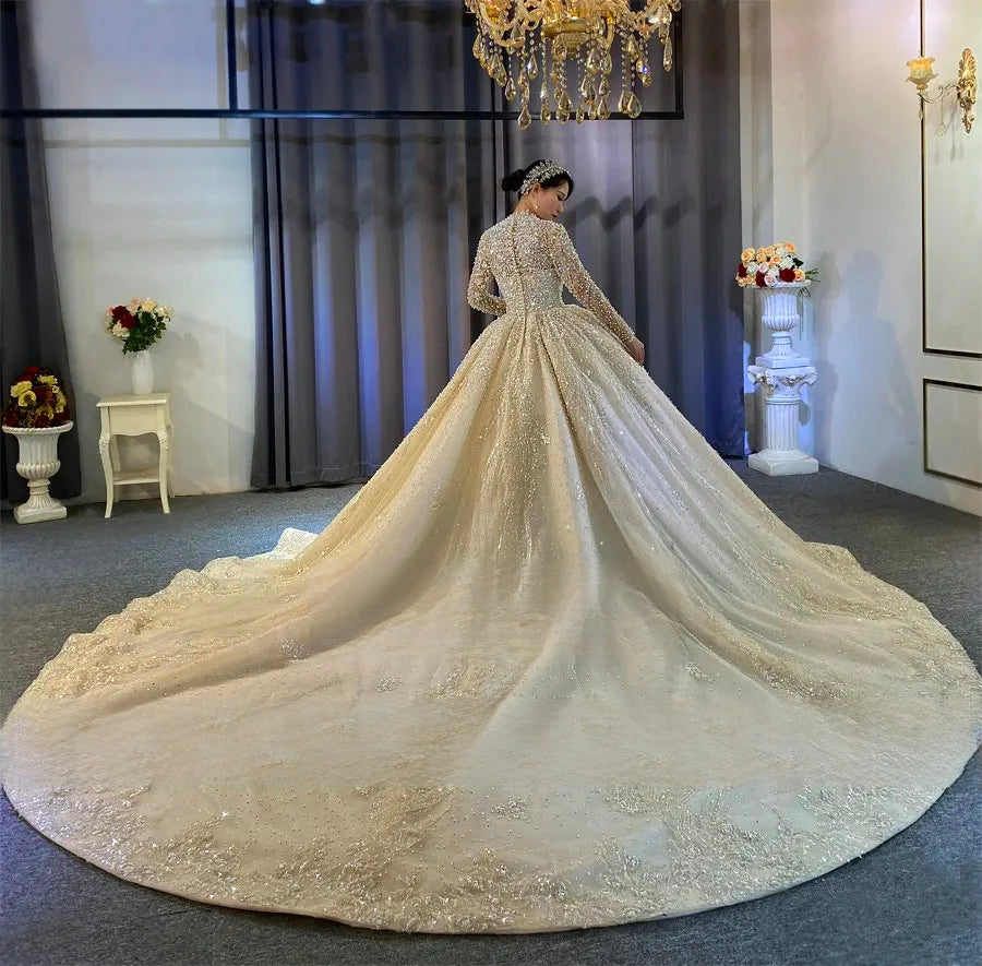 Majestic rear view of an elegant pearl-encrusted ball gown wedding dress highlighting an expansive cathedral-length train spread across a showroom floor.