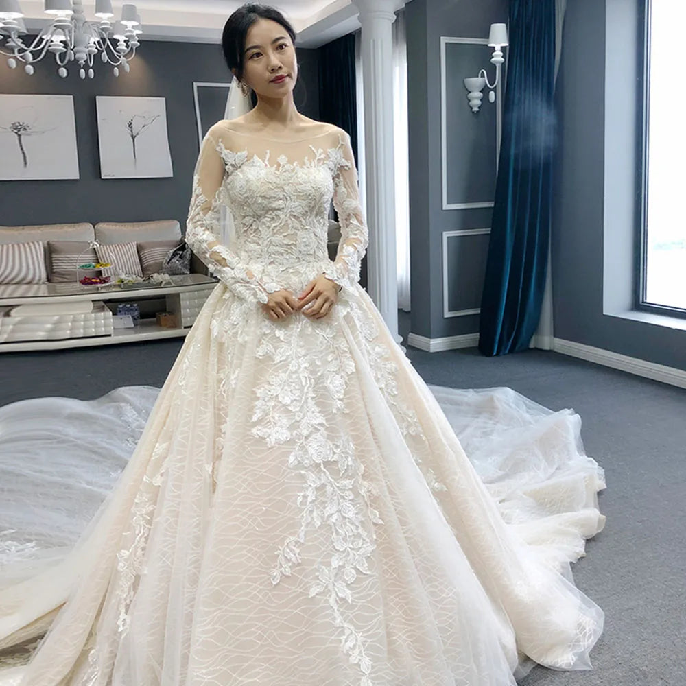 Elegant full sleeve A-line wedding dress with intricate beaded appliques and a flowing long train.