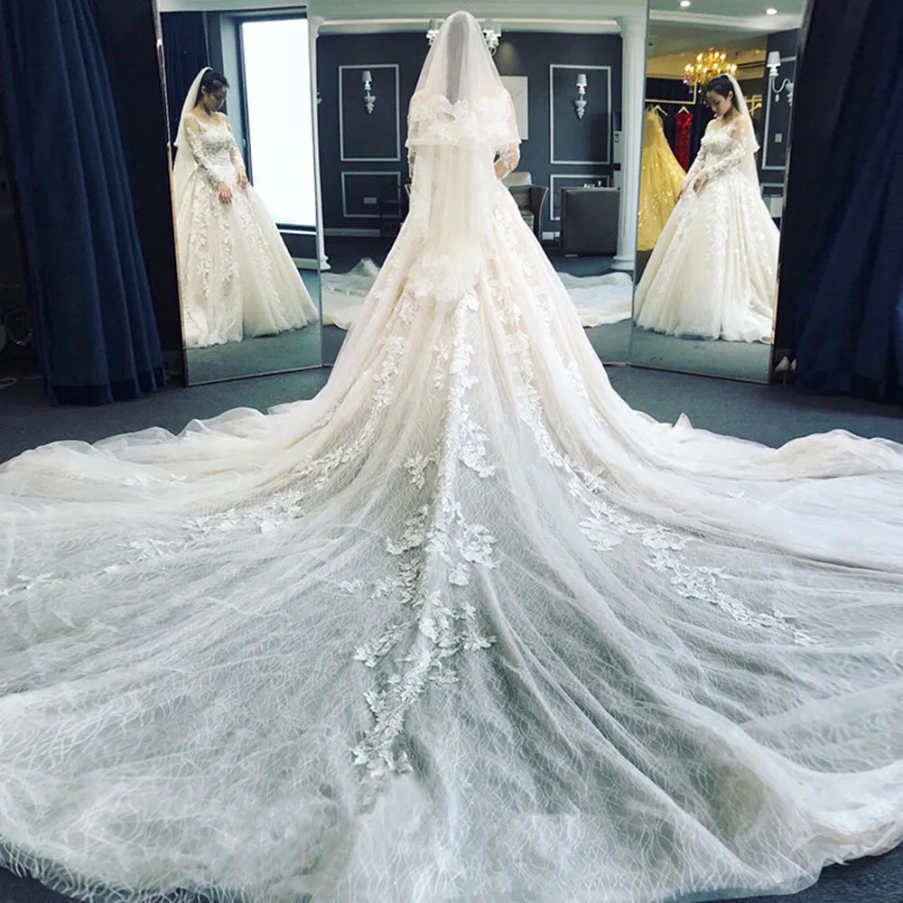 Back view of a stunning full-sleeve wedding dress with a long, flowing train and delicate lace detailing.