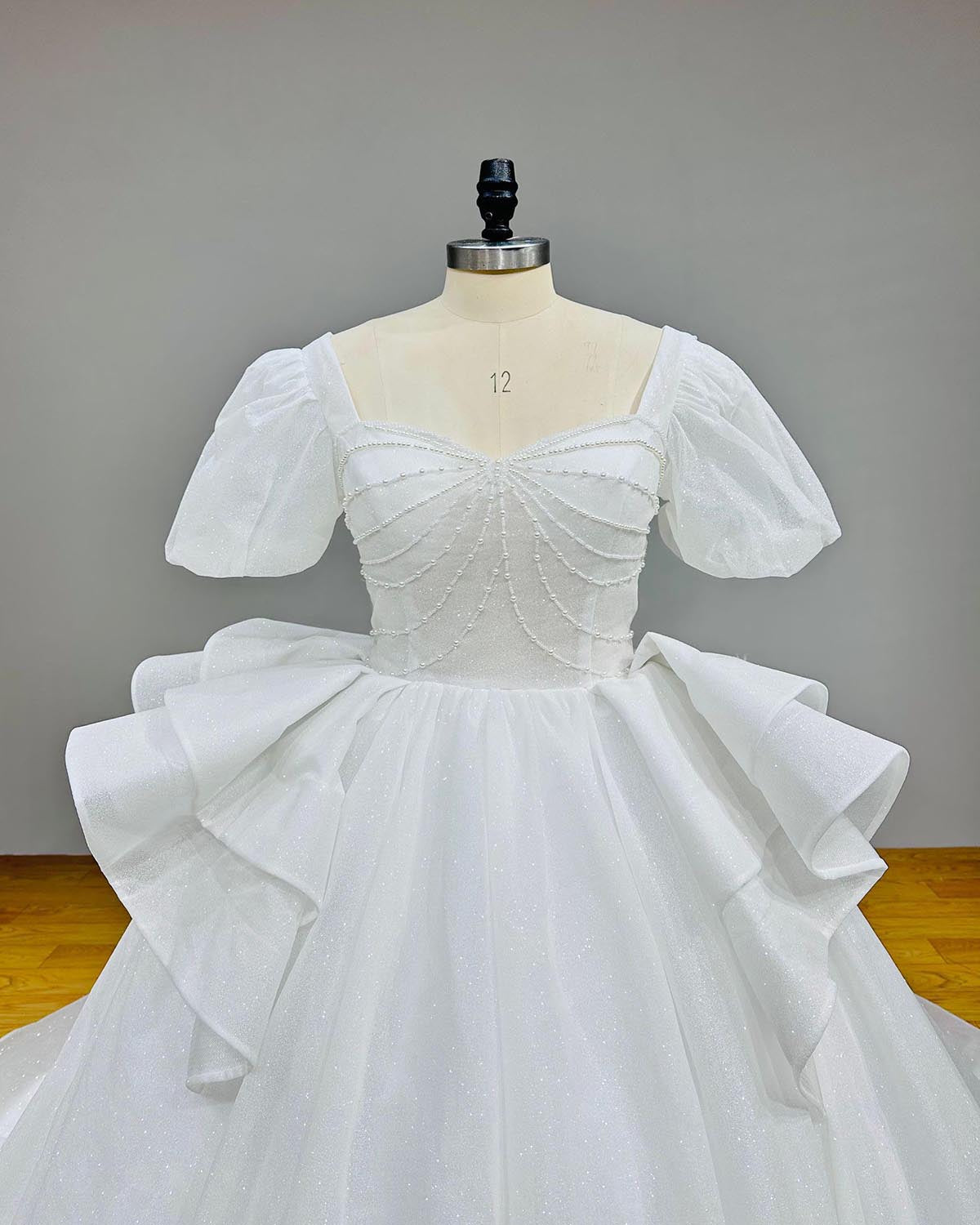 Close-up detail of the glitter sweetheart neckline bodice on a luxury short-sleeve bridal ball gown.