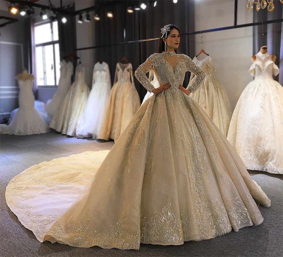 Front pose of a bride in a shimmering gold high-neck wedding dress with long sleeves, highlighting the grand royal princess silhouette and high-quality craftsmanship.