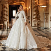 A bride standing in an ornate hall, wearing a gorgeous A-line ball gown wedding dress with long sleeves, high neck, and intricate lace appliques.