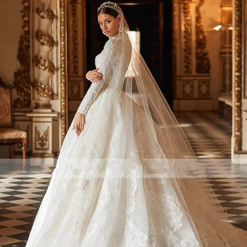 A back view of a bride showcasing a gorgeous A-line ball gown wedding dress featuring elegant lace appliques and a dramatic chapel train.