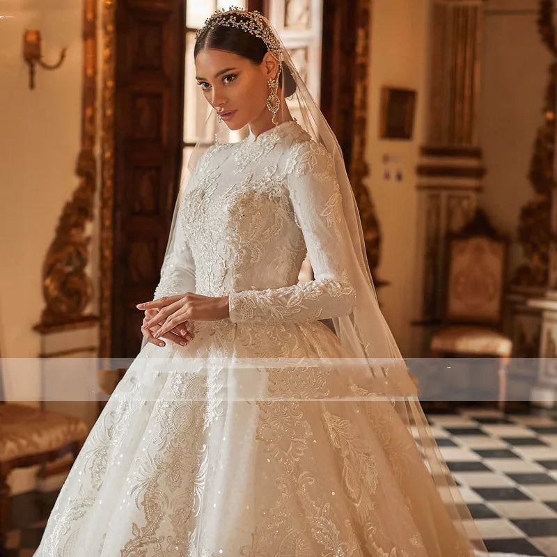 A side portrait of a bride wearing a gorgeous high-neck, long-sleeve A-line ball gown wedding dress with detailed lace appliques.