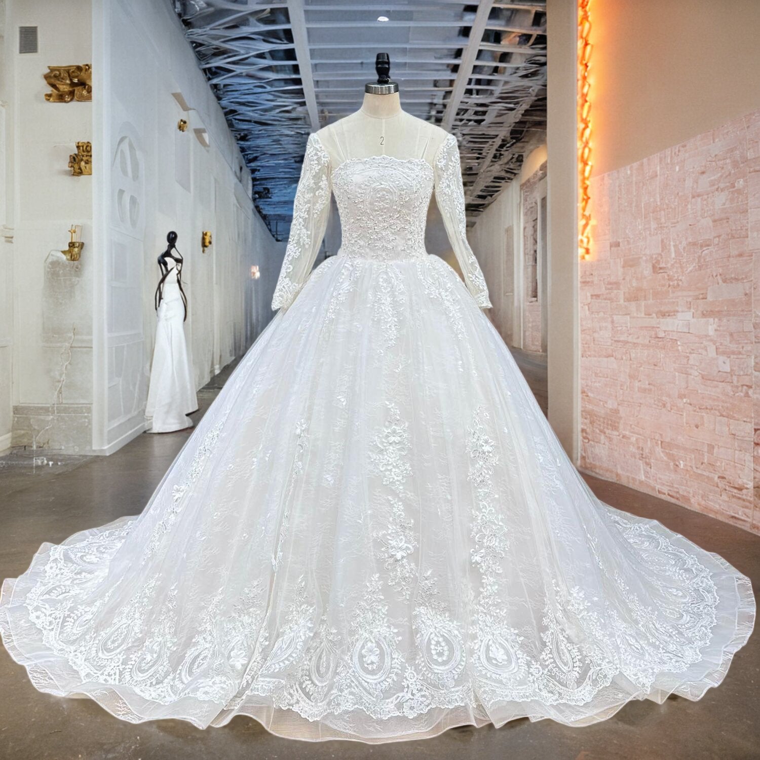 Elegant long-sleeve white lace princess wedding dress with a structured square yoke neckline and a wide-flared tulle-and-satin skirt, shown on a mannequin in a showroom hall.