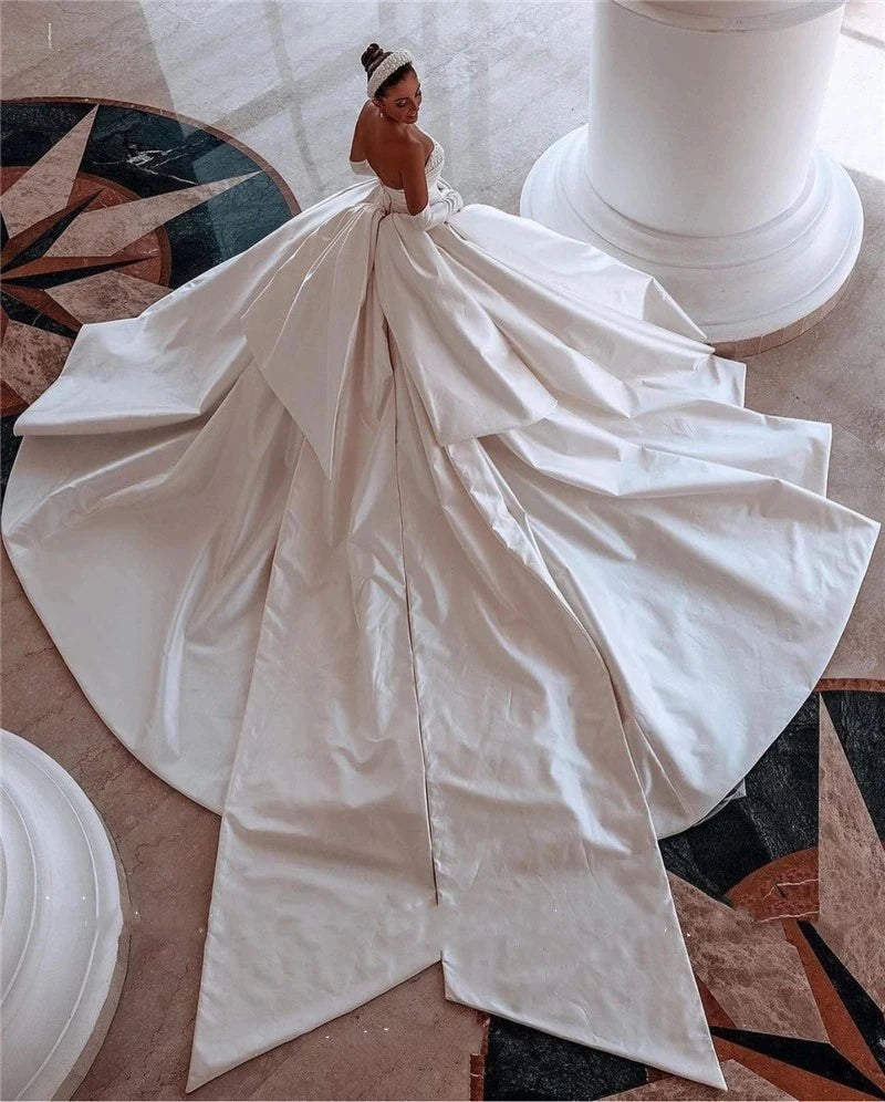 A high-angle view of a princess-style wedding dress featuring a voluminous skirt and a dramatic, grand train.