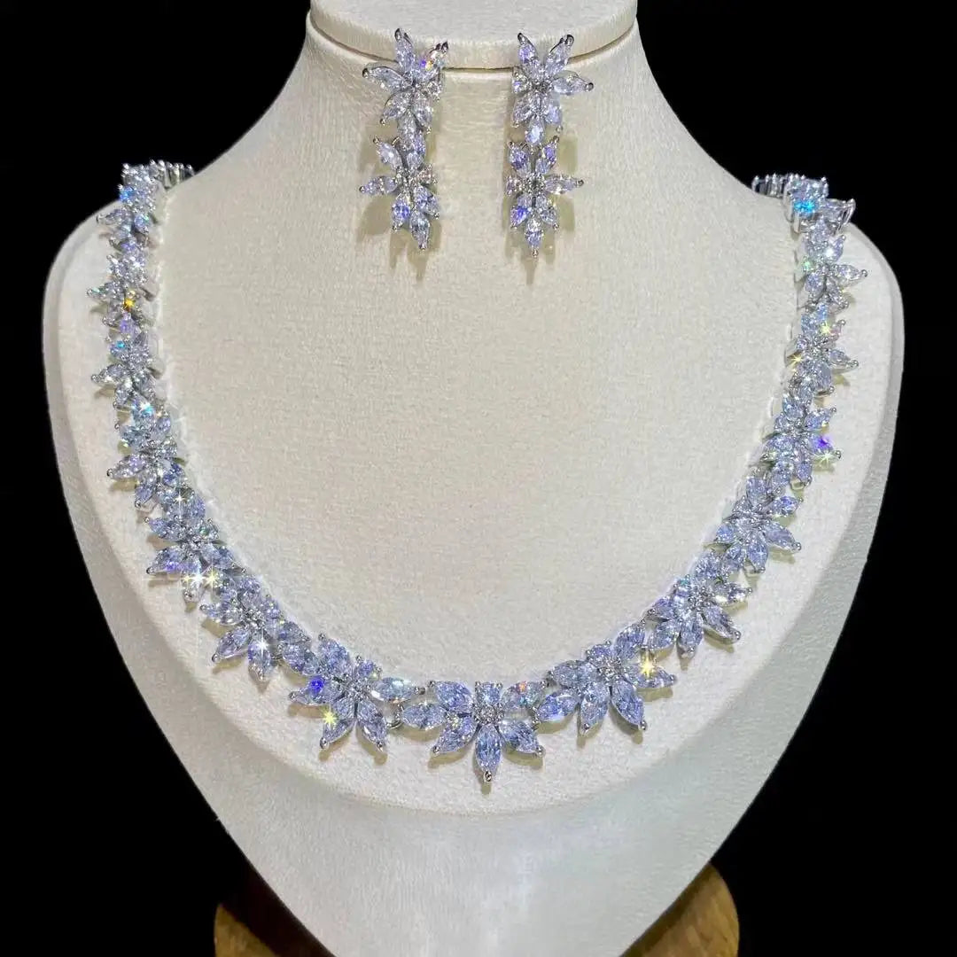 Front profile of a sparkling marquise crystal wedding necklace and matching long dropdown earrings set on a white display bust.