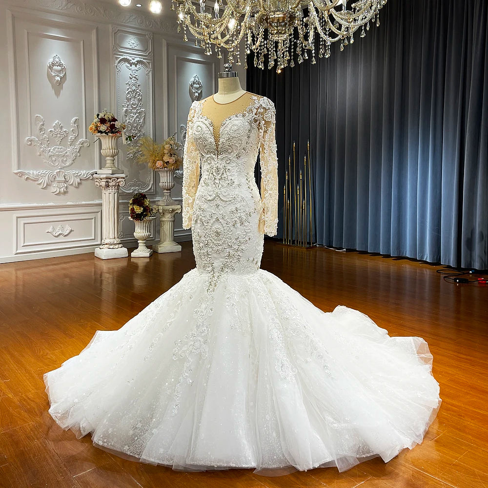 Luxury mermaid wedding dress displayed on a mannequin, showcasing the fitted silhouette and a dramatic, expansive puffy skirt with a long train.