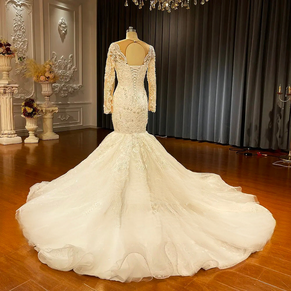 Back view of a mermaid wedding dress with a dramatic puffy skirt and a long, sweeping train, perfect for an elegant bridal look.