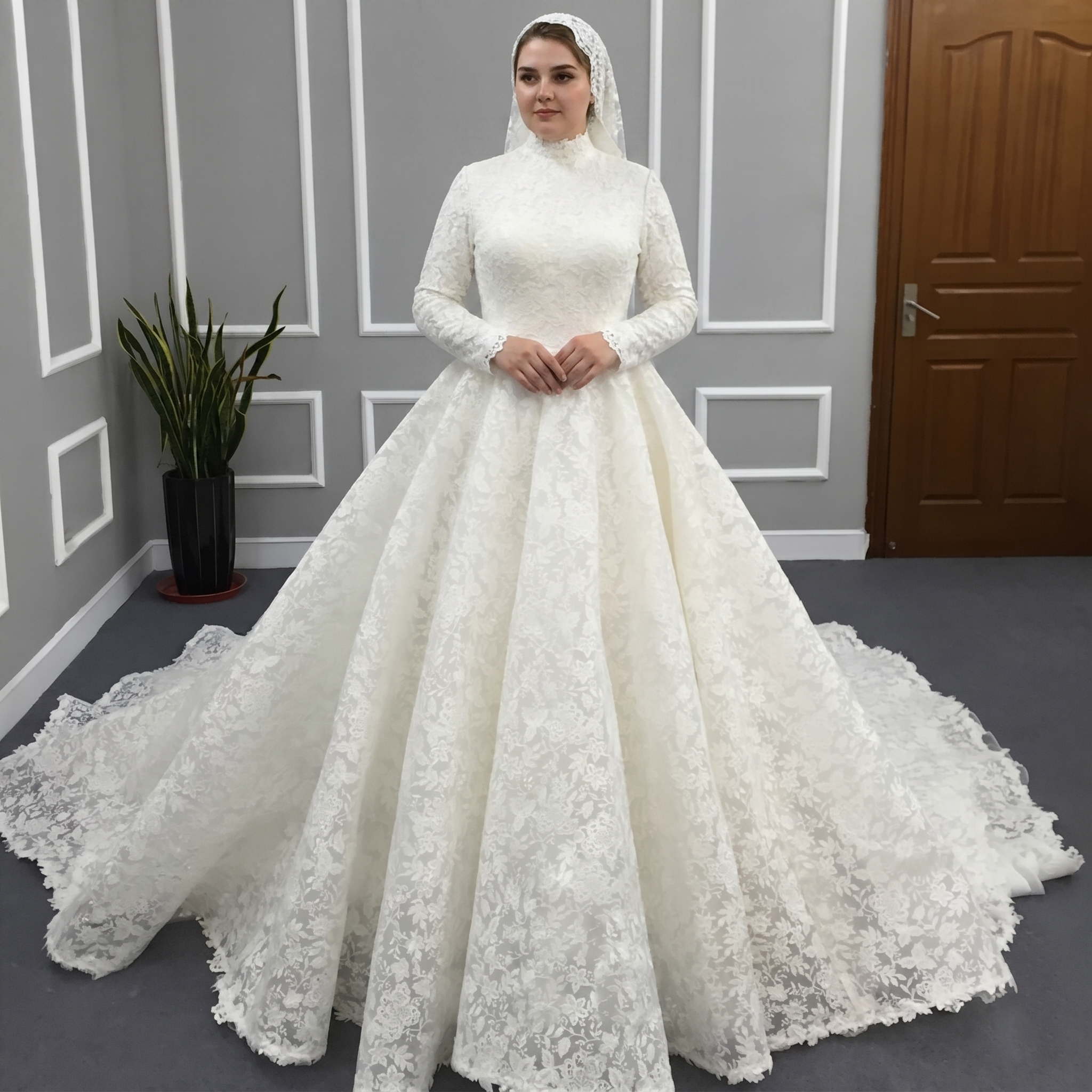 Front view of a woman wearing a modest high neck long sleeve princess lace A-line Muslim wedding dress with a petticoat for added volume.