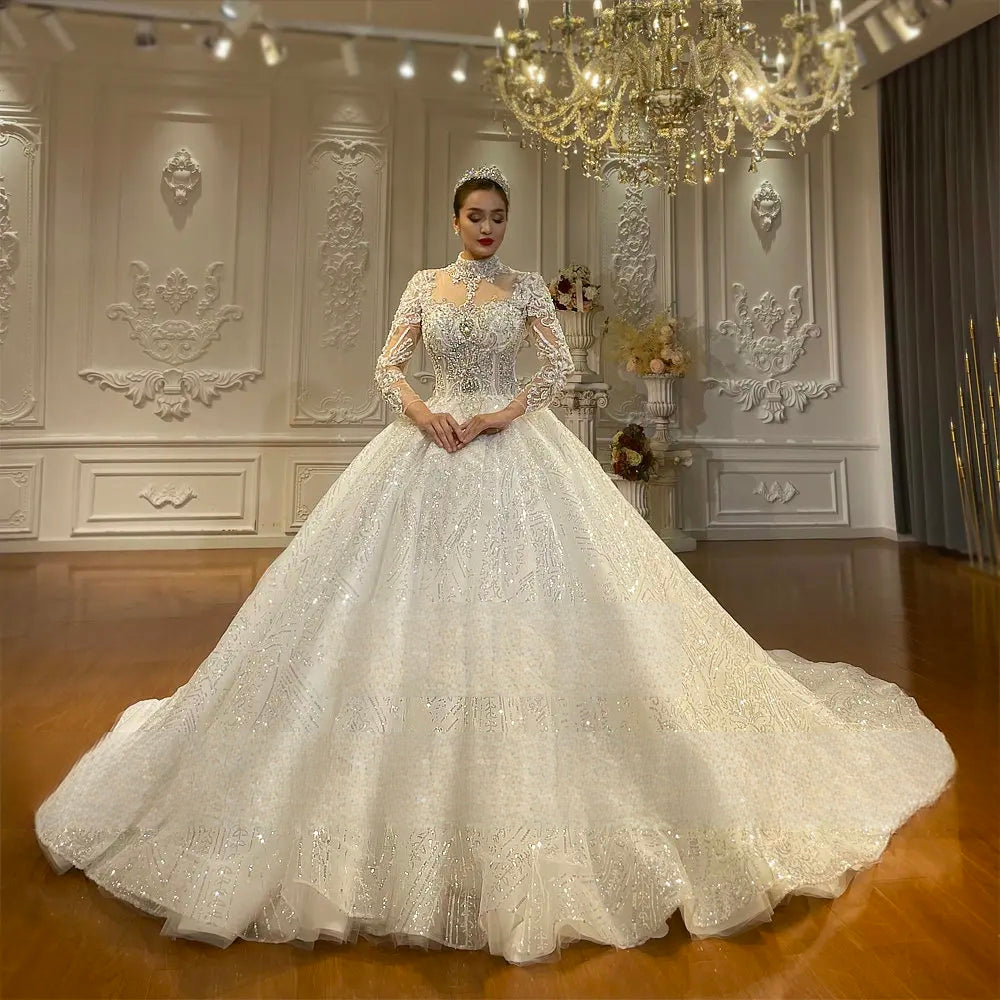 Full-length front view of a grand high neckline ball gown bridal dress with voluminous layers of shimmering lace and elegant long-sleeve detailing.