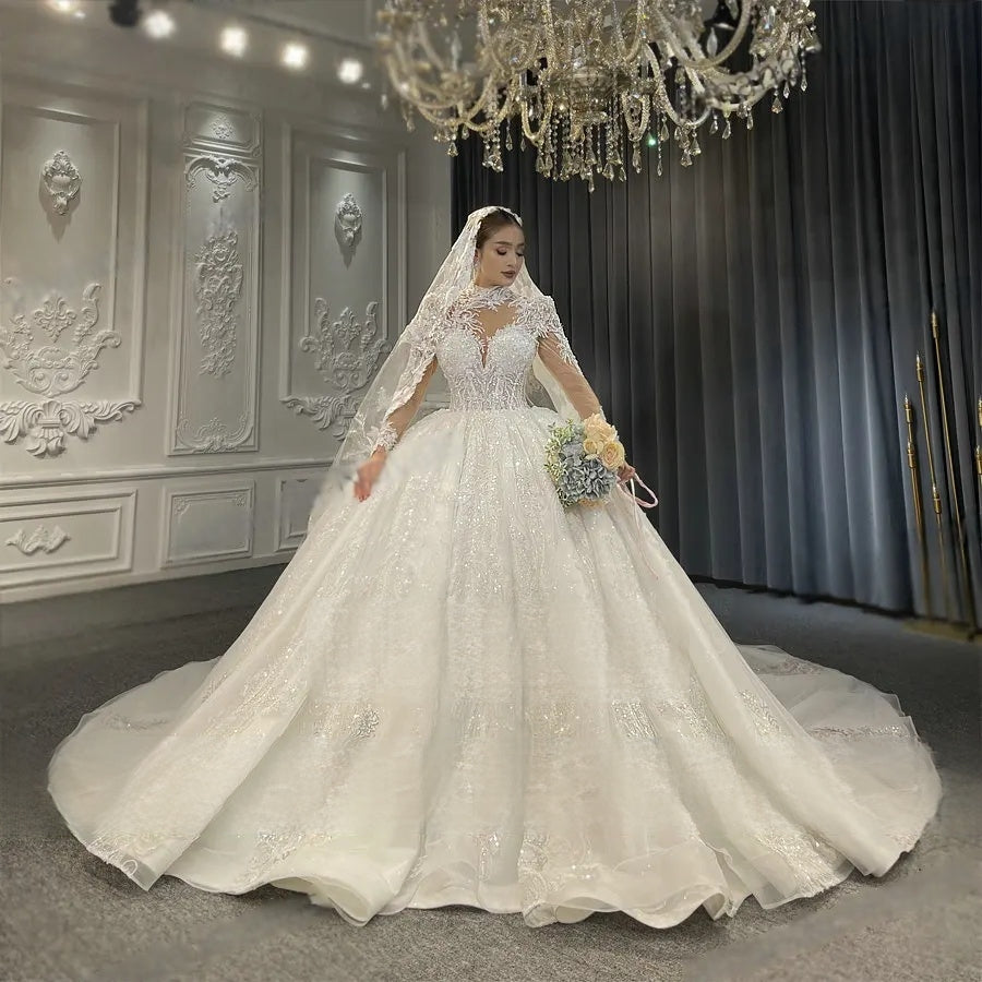 Radiant bride posing in a luxury high-neck lace ball gown, showcasing the intricate silver floral embroidery and the regal scale of the shimmering white skirt.