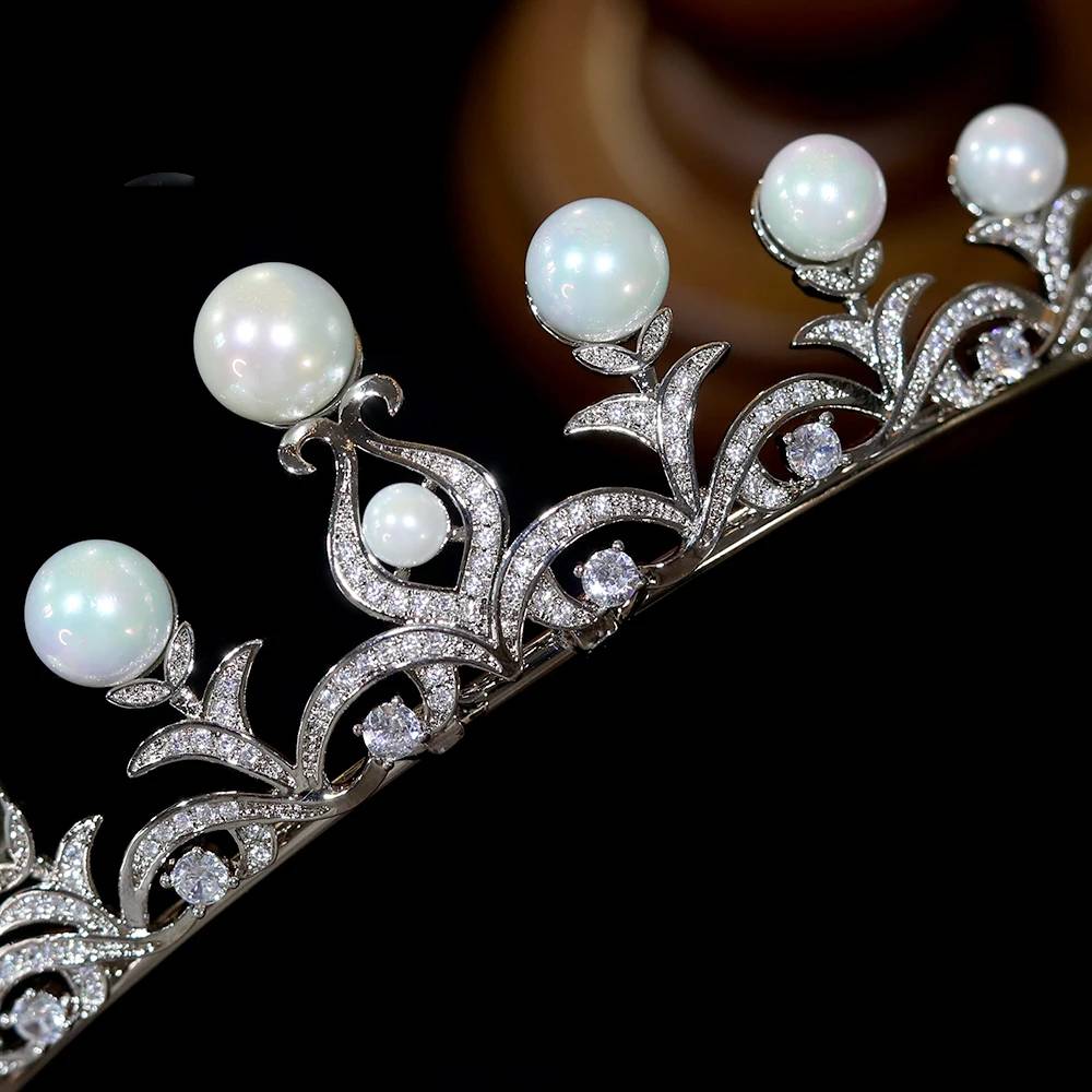 Macro close-up view of the intricate pave cubic zirconia stone settings and graduated white pearls on a princess bridal tiara.