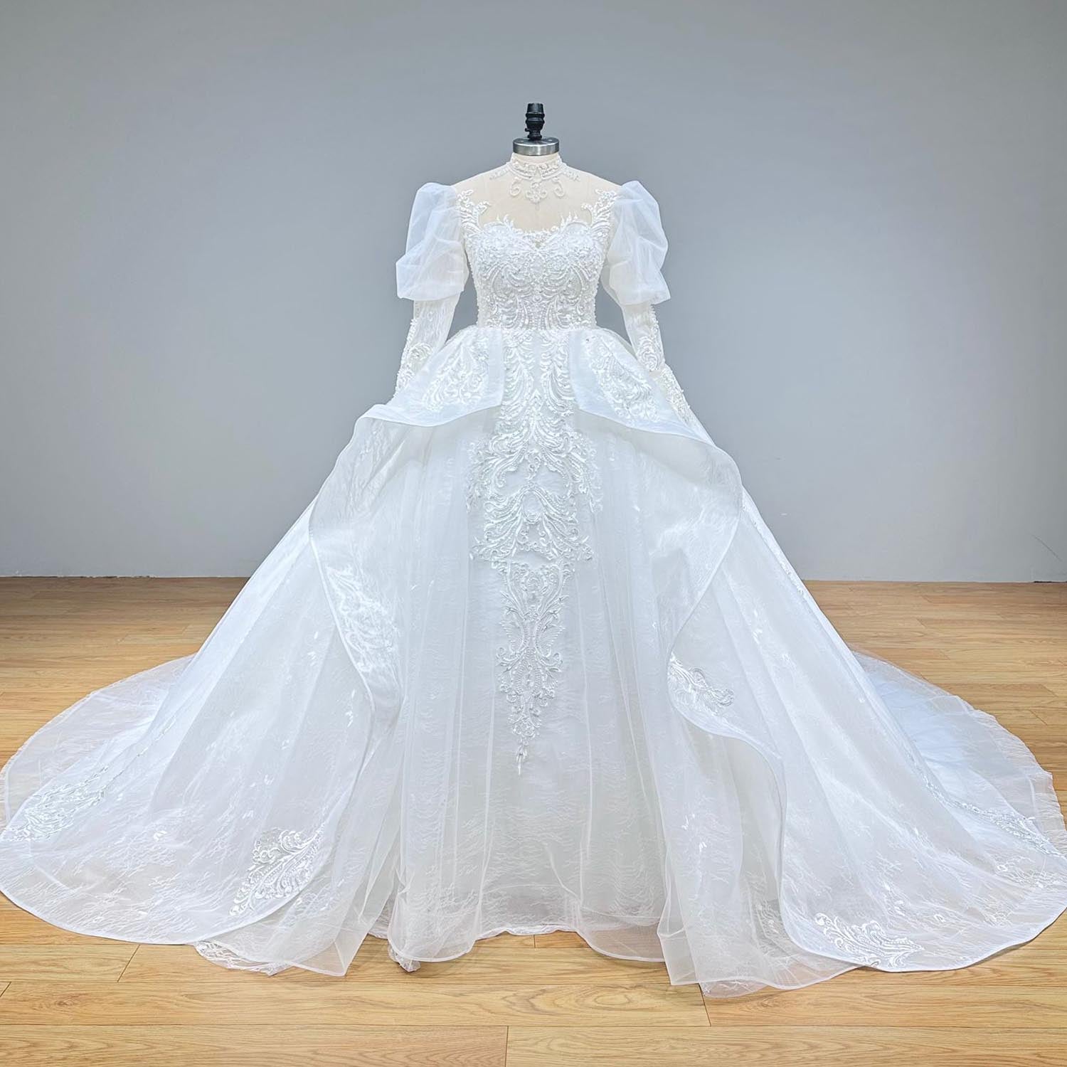 Classic full-length front shot of a formal high-neck puff sleeve ball gown on a mannequin, highlighting the seamless transition from the lace-beaded bodice to the grand, full bridal skirt.