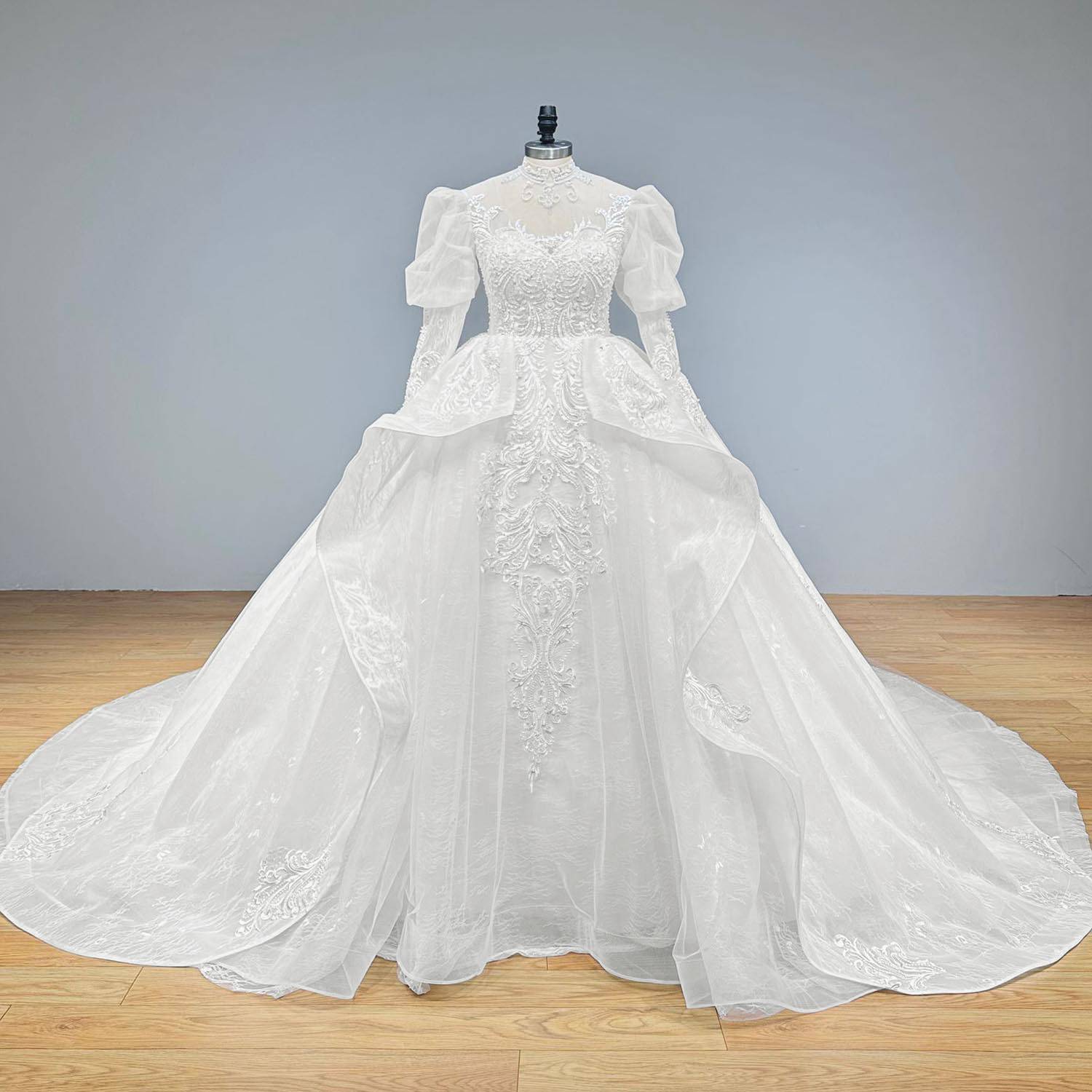 Classic full-length front shot of a formal high-neck puff sleeve ball gown on a mannequin, highlighting the seamless transition from the lace-beaded bodice to the grand, full bridal skirt.