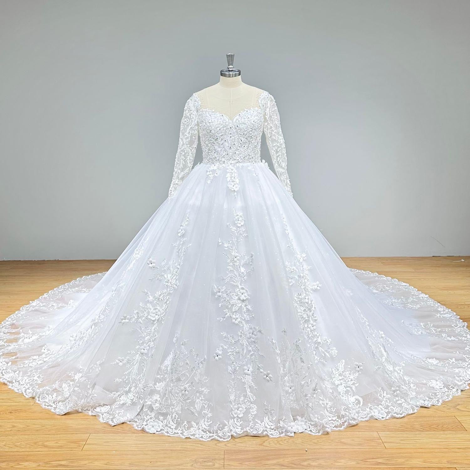 Front view of a long-sleeve beaded ball gown wedding dress with a sweetheart neckline and detailed floral lace embroidery.