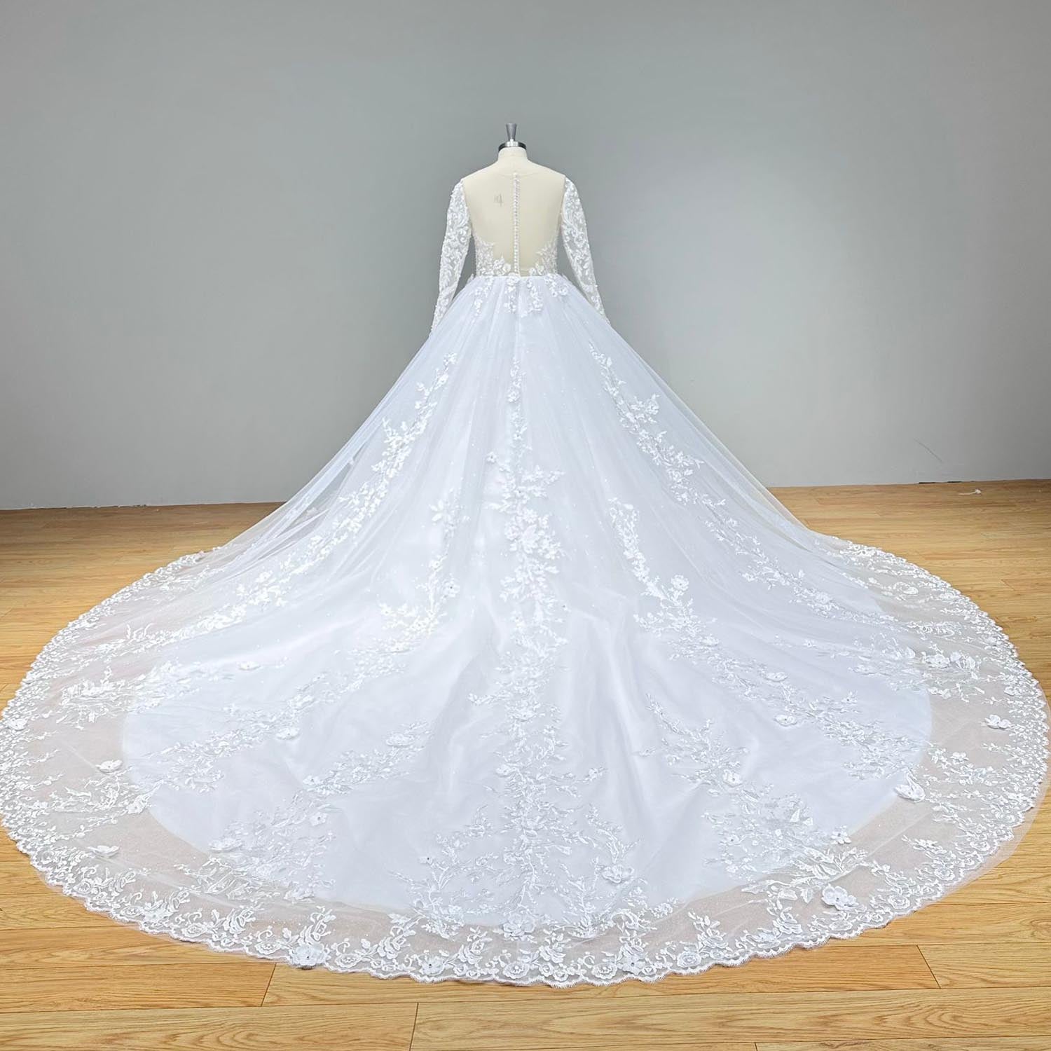 Back view of a long-sleeve beaded ball gown wedding dress showcasing a dramatic lace-embellished train and illusion detailing.