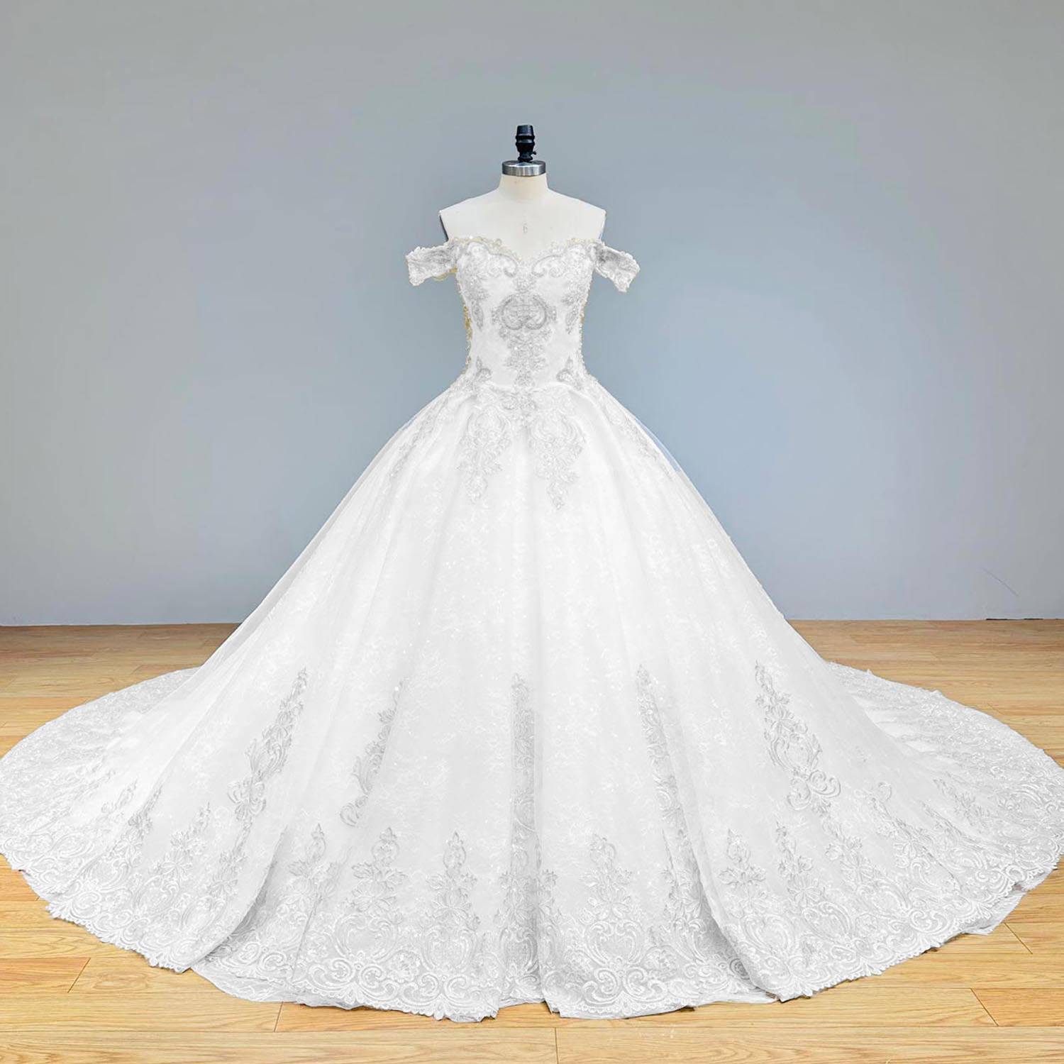 Full-length front profile of a white and gold off-shoulder beaded ball gown wedding dress displayed on a mannequin.