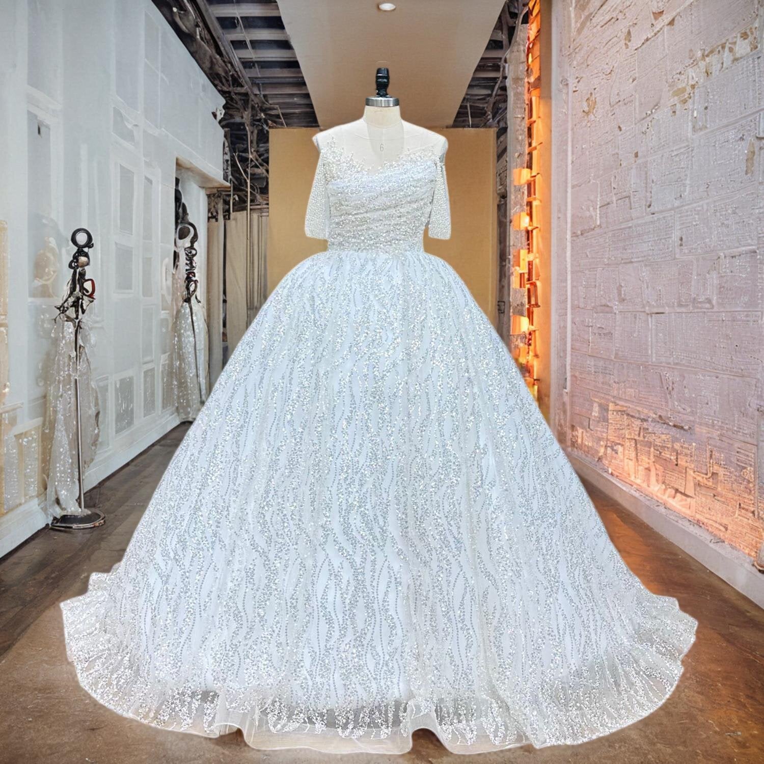 Full-view of a sequined and pearl-embellished ball gown bridal dress with short sleeves displayed on a mannequin.