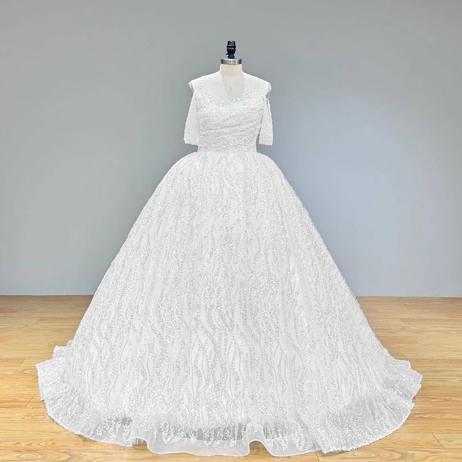Front view of a glamorous sequin and pearl ball gown wedding dress with short sleeves and full skirt.