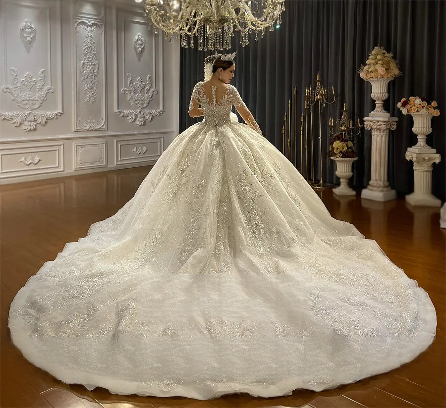 Dramatic rear perspective of a luxury princess wedding gown, showcasing an expansive glittering cathedral train and intricate beaded lace details.