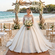 A beautiful bride on a beach wearing a hot sale long-sleeved wedding dress with elegant lace detailing and a flowing skirt, standing under a floral archway.