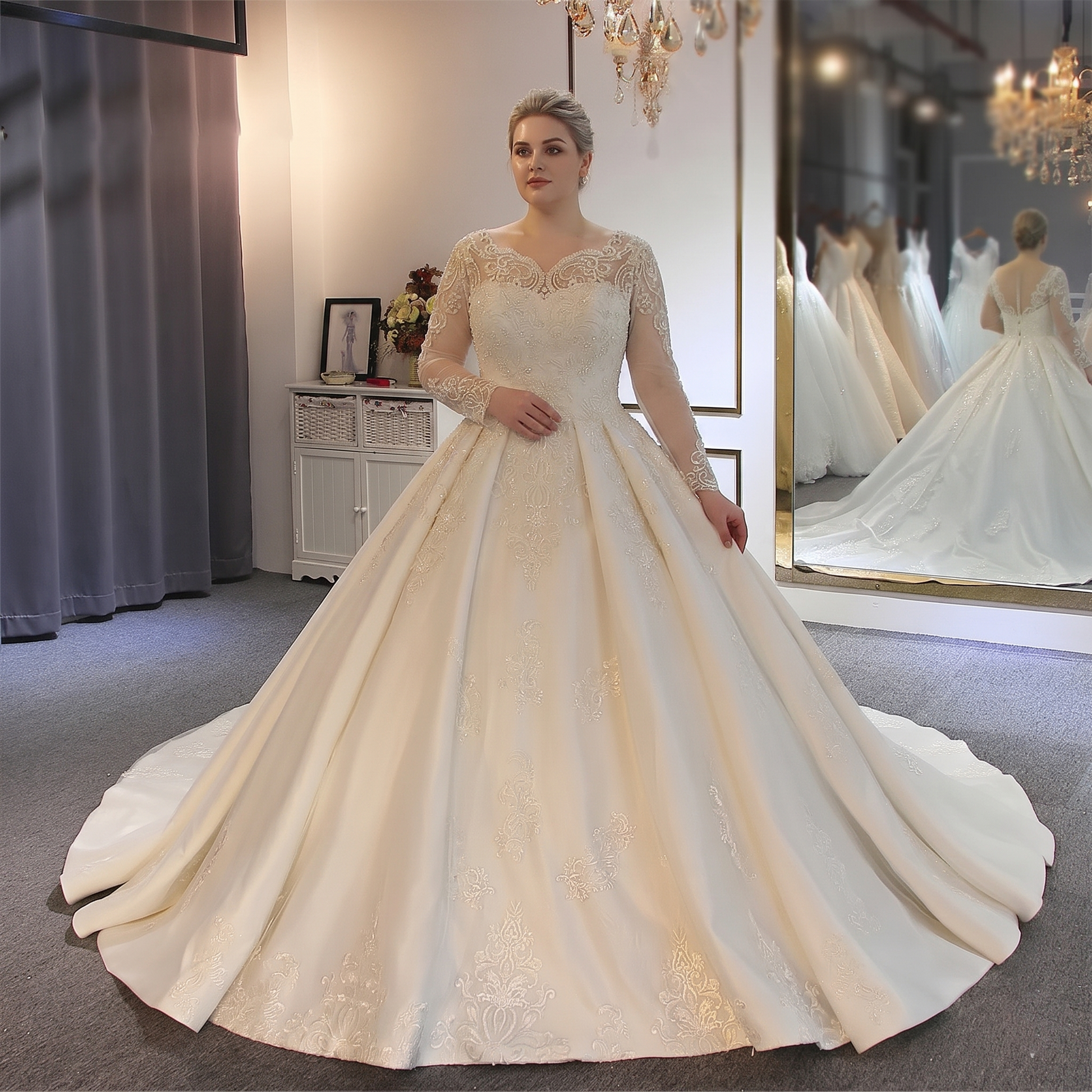 An elegant designer bridal gown featuring long lace sleeves, a delicate illusion neckline with intricate embellishments, and a full, majestic skirt in a boutique setting.