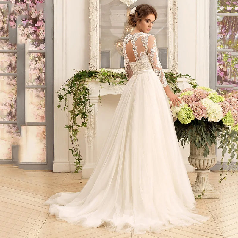 A detailed back view of a bride in an A-line wedding gown, highlighting the intricate illusion lace back design and elegant bridal train.