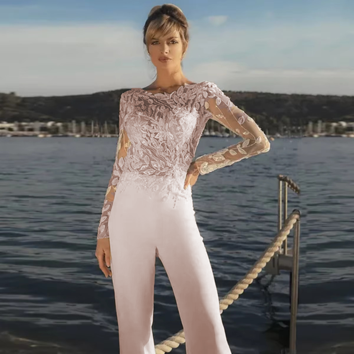 Front profile view of the long-sleeve illusion lace top bridal pantsuit, rendered in a subtle blush pink tint option for an alternative wedding day style.