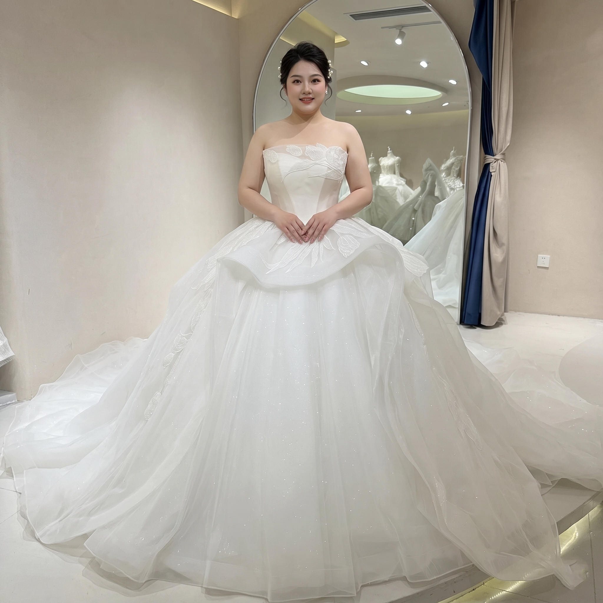 Back view of a sleeveless ivory bridal ball gown featuring an elegant lace-up corset back and a grand shimmering cathedral-length train.