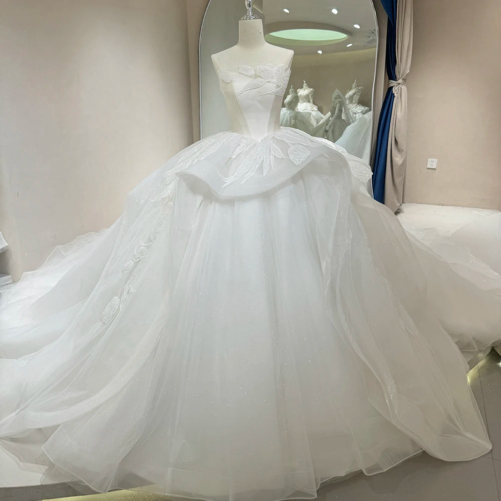 Side-angle profile of a glittery ivory princess wedding dress showcasing the dramatic volume of the ball gown silhouette and reflective sparkle fabric.