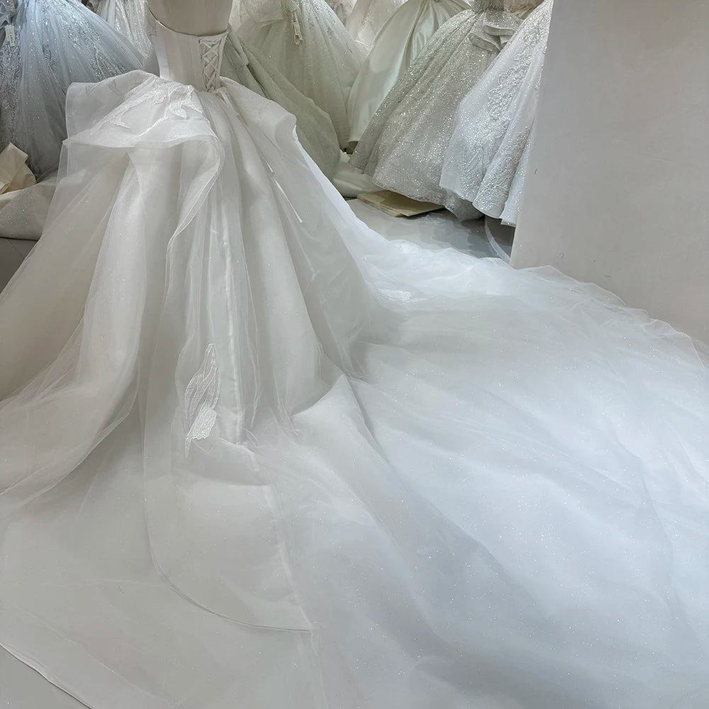 Close-up of the sweetheart bodice and upper skirt of an ivory strapless bridal gown, highlighting the dense glitter texture and high-quality shimmering finish.