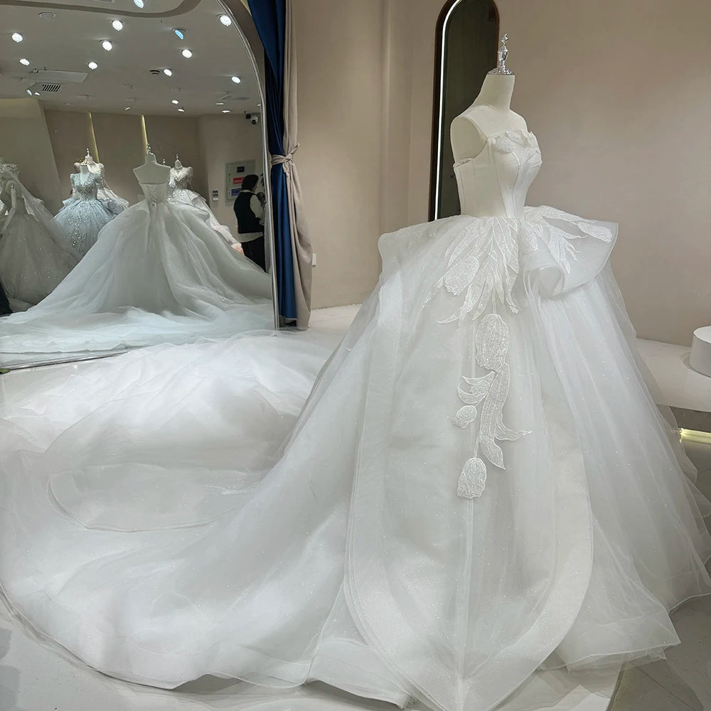 Wide-angle rear shot of a majestic ivory glitter ball gown train spread across a studio floor, emphasizing the royal princess aesthetic.