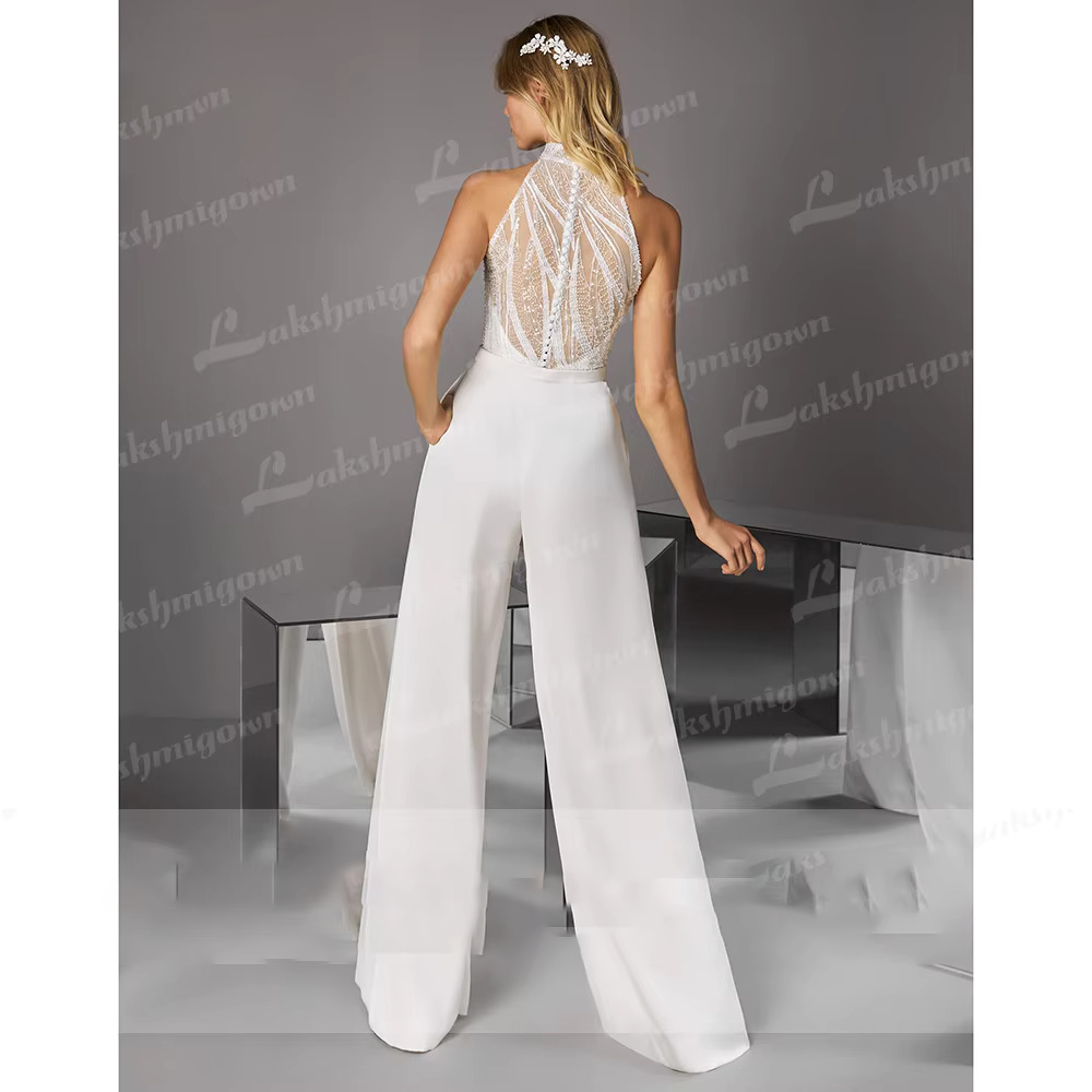 Rear three-quarter view frame of the sequined bridal jumpsuit gown, highlighting the sophisticated high-waisted tailoring and geometric lace patterning on the back bodice.