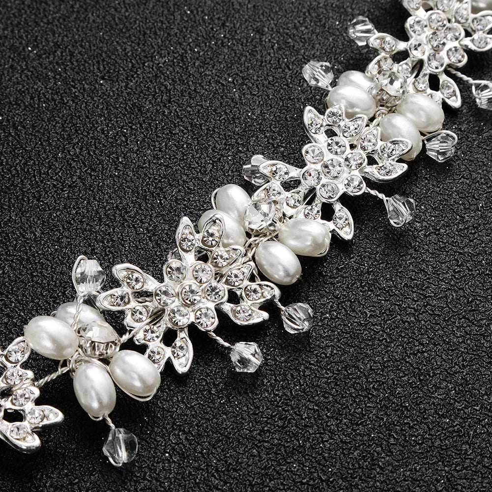 Macro detail of the intricate floral wirework, pearls, and sparkling crystals on a bridal hairband.