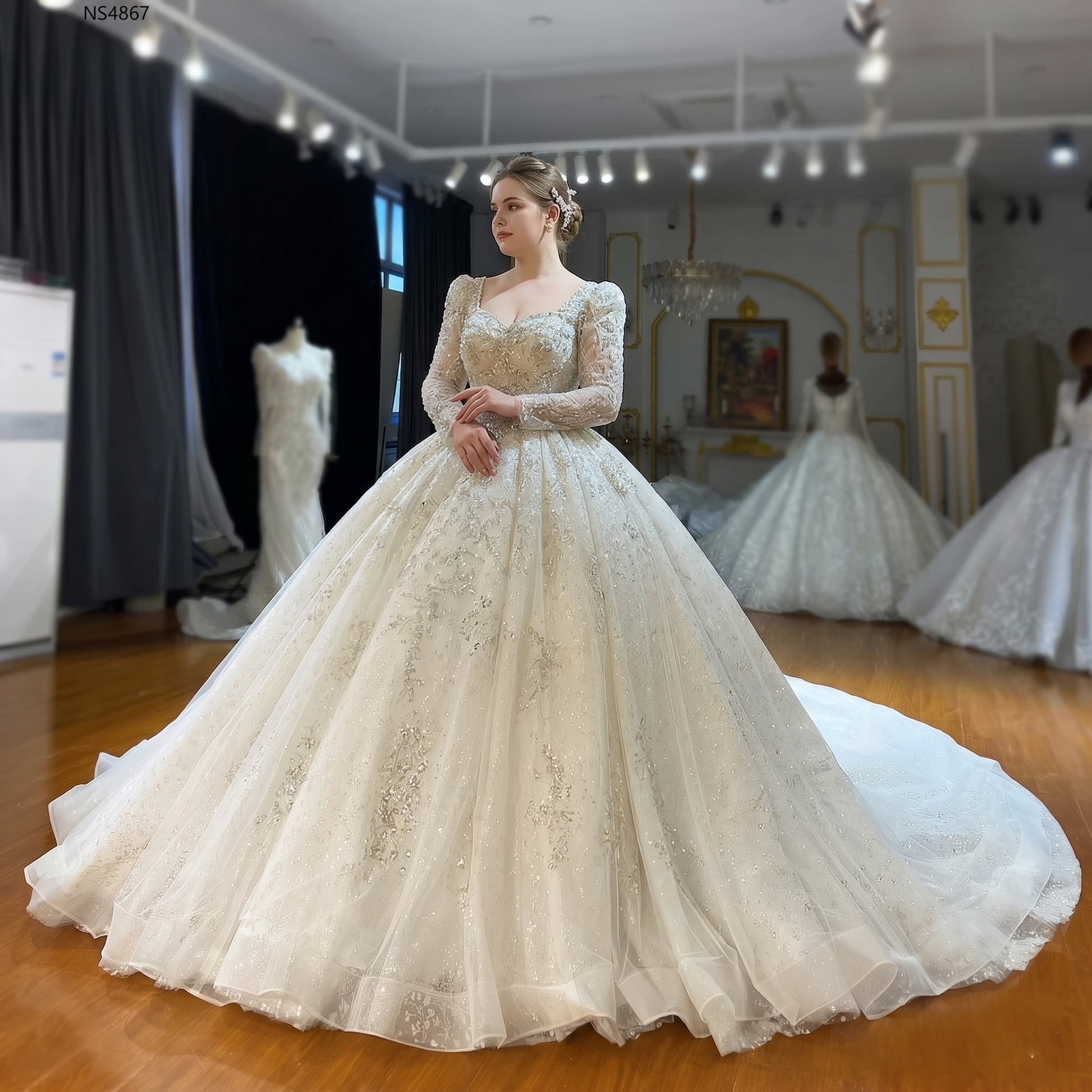 Elegant front perspective of a plus-size model showcasing a luxury long-sleeve ball gown wedding dress with intricate crystal embroidery and a voluminous sparkling skirt.