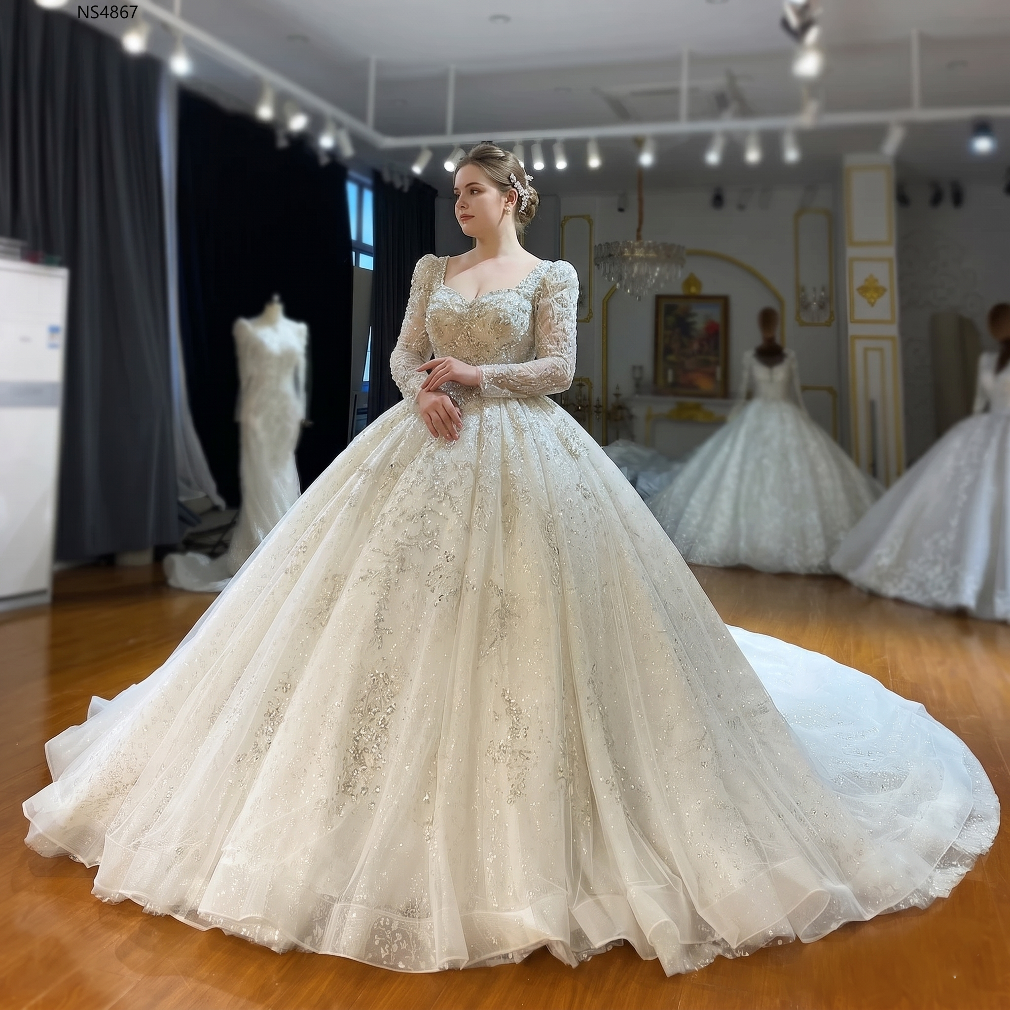 Elegant front perspective of a plus-size model showcasing a luxury long-sleeve ball gown wedding dress with intricate crystal embroidery and a voluminous sparkling skirt.