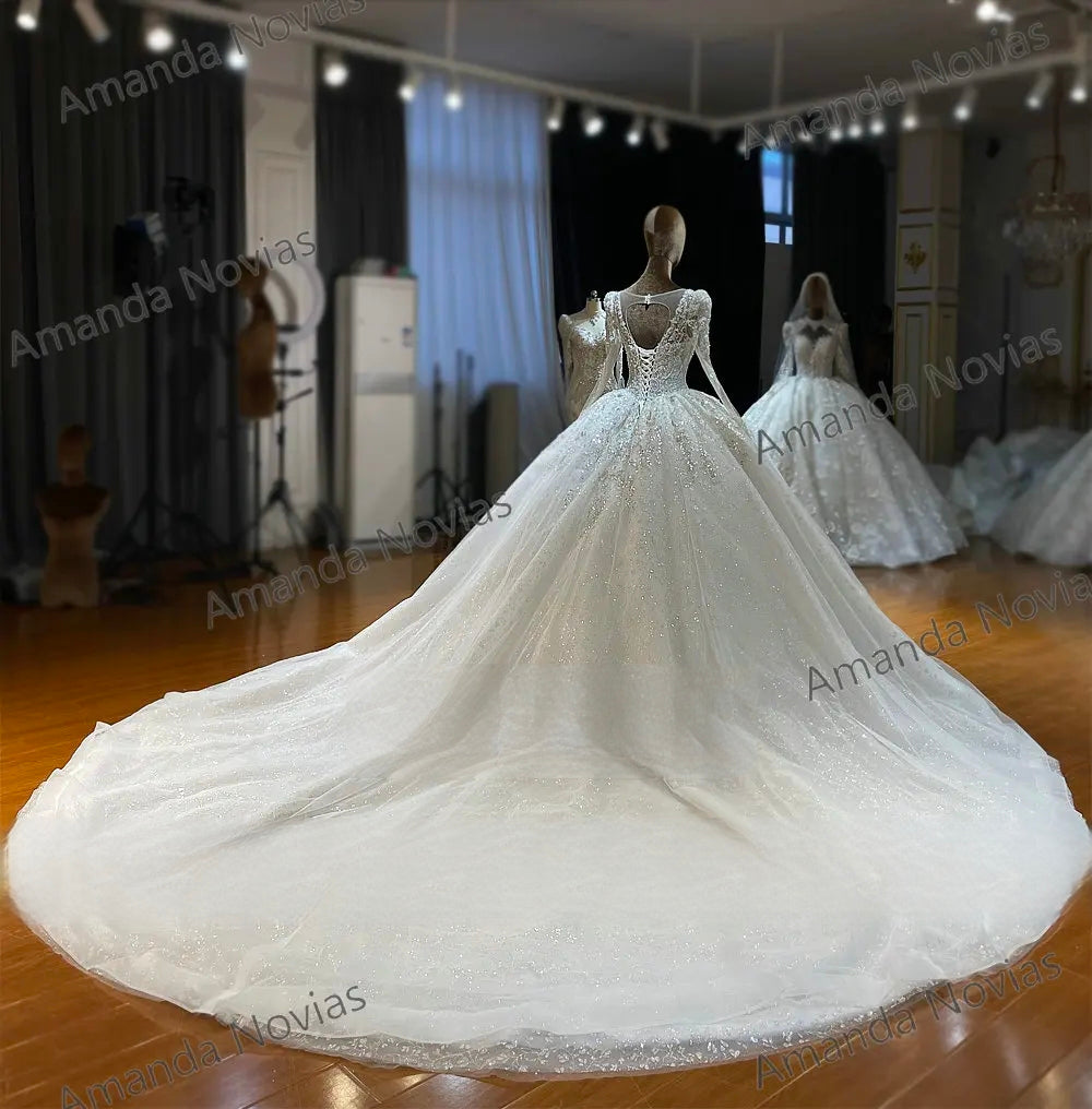 Breathtaking back view of an exquisite ball gown wedding dress on a mannequin, featuring a classic lace-up corset, a sheer keyhole back design, and an expansive shimmering cathedral train.
