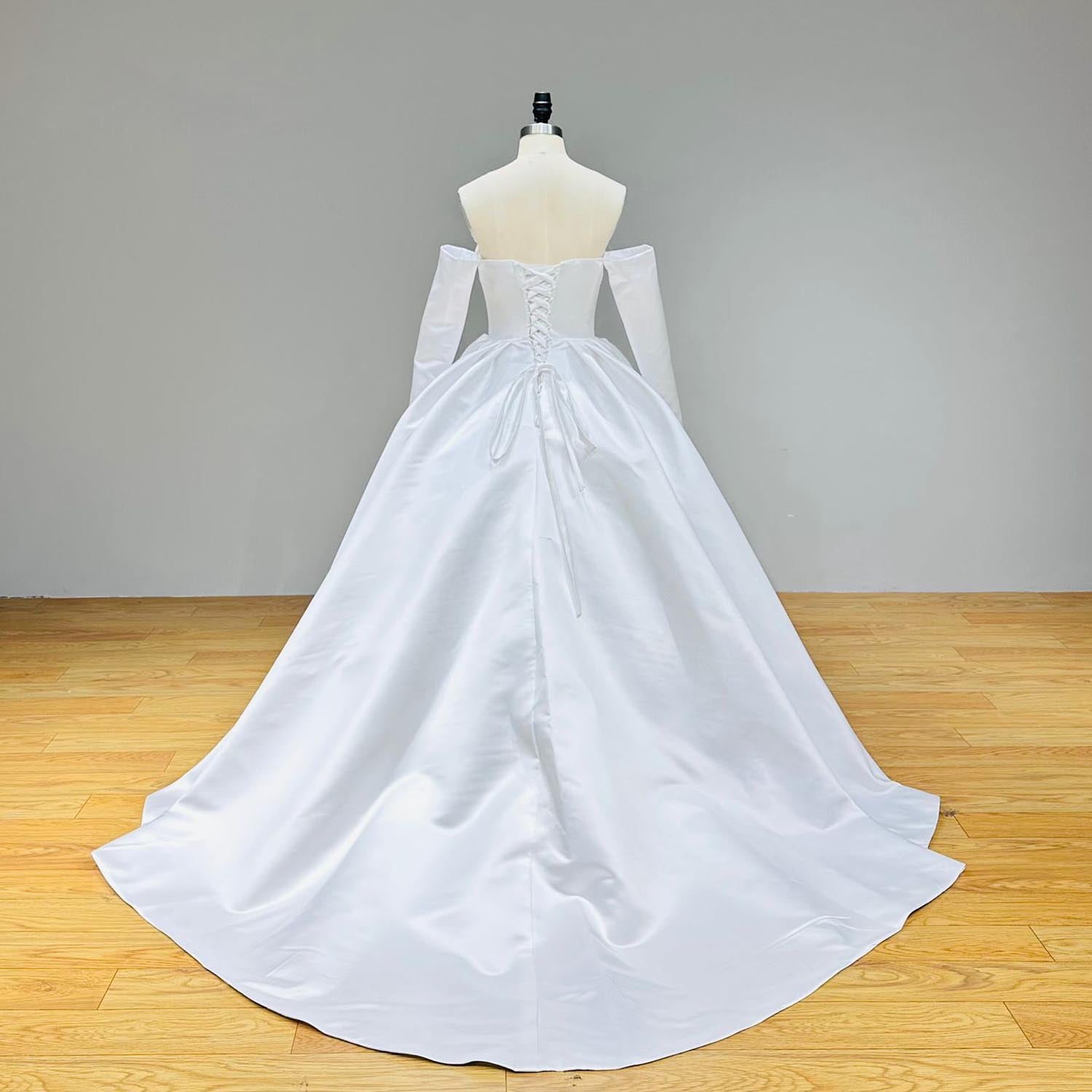 Full back view of a light effect satin ball gown wedding dress on a mannequin, displaying a classic lace-up corset back, detached long sleeves, and a smooth, elegant flowing train.